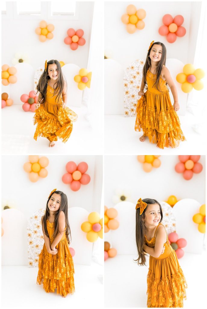 girl in boho dress with balloons and floral backdrop