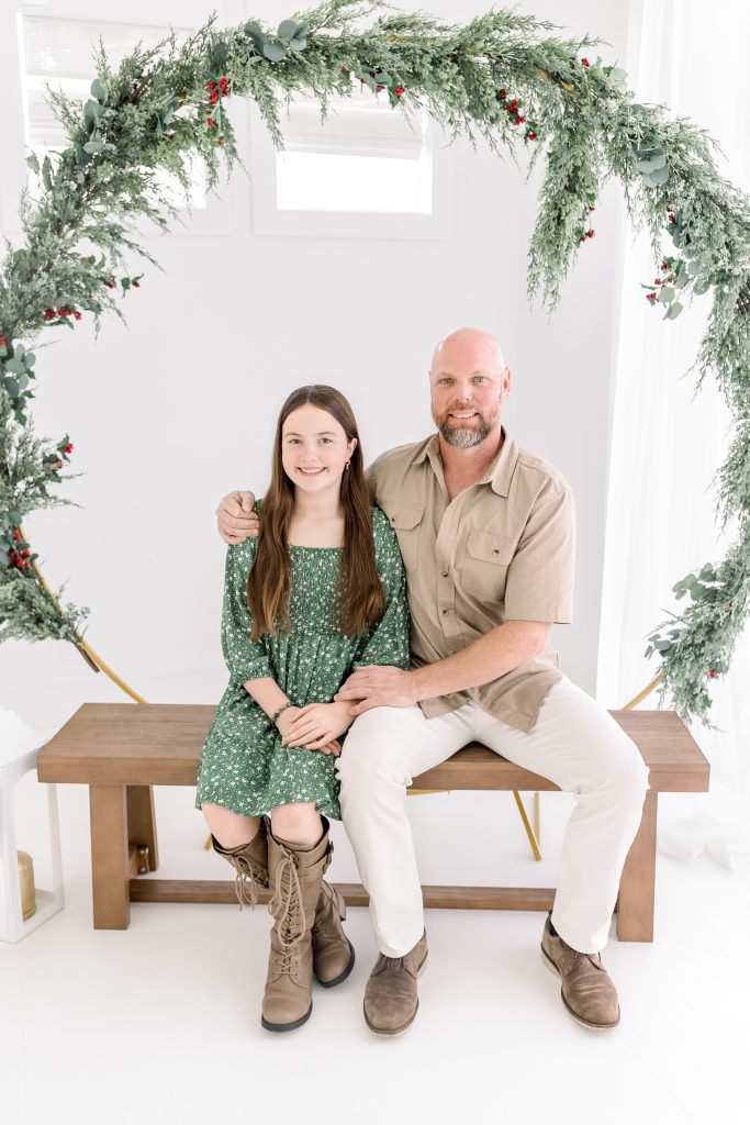 family sitting on a bench for holiday session