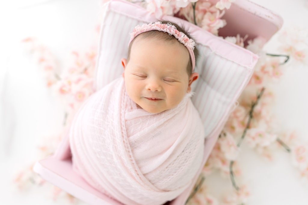 Close-up of a newborn baby girl, smiling